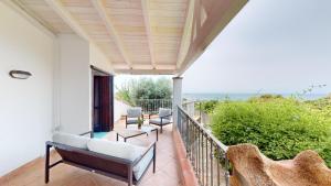 a balcony with chairs and a view of the ocean at Villa Marina in Campu Longu
