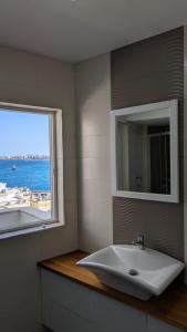 ein Badezimmer mit Waschbecken und Fenster in der Unterkunft Honeymoon Seaview in St Paul's Bay