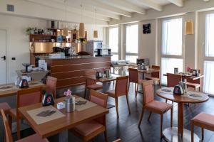 a restaurant with tables and chairs in a room at Hotel Giallo in Noceto