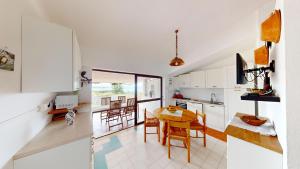 a kitchen and dining room with a table and chairs at Villa Marina in Campu Longu +30 photos