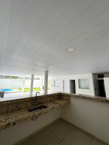 a kitchen with a sink and a large window at Casa na praia, Balneário de Carapebus in Serra