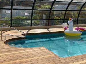 een zwembad met een opblaasbaar speeltje in het water bij Camping 3 étoiles - Piscine - eehhec in Landry