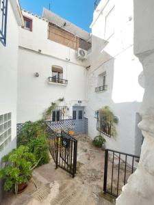 a courtyard of a white building with a gate at Casa Almachar in Cómpeta
