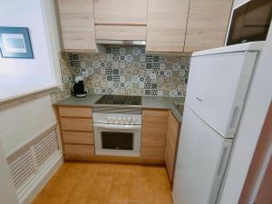 a small kitchen with a stove and a refrigerator at Apartamentos Eldorado in Lloret de Mar