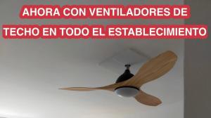 a wooden ceiling fan in a room with a sign at Apartamentos Eldorado in Lloret de Mar