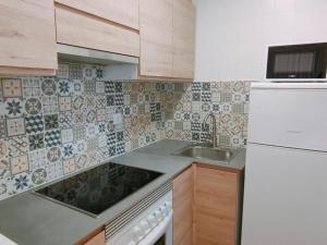 a kitchen with a sink and a white refrigerator at Apartamentos Eldorado in Lloret de Mar