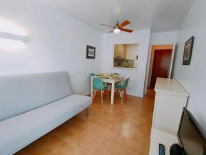 a living room with a couch and a table with chairs at Apartamentos Eldorado in Lloret de Mar
