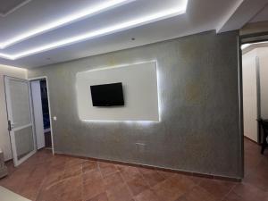 a room with a wall with a tv on it at Marinasmir Jawhara in Fnidek