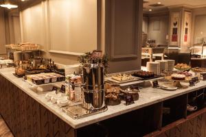 a buffet line with cakes and desserts on a table at Grand Poet Hotel and SPA by Semarah in Rīga