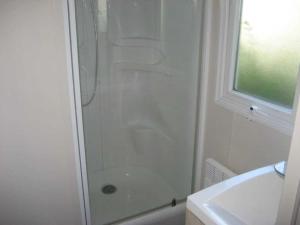 a white bathroom with a shower and a sink at Camping 3 étoiles - Parc aquatique - ccaehgc in Déols +30 photos
