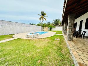 a backyard with a pool and a table in the grass at Casa Bela Araçagy, 400m da praia. in São-José-do-Ribamar