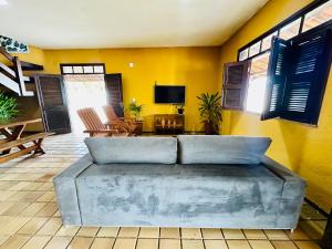 a living room with a large couch and yellow walls at Casa Bela Araçagy, 400m da praia. in São-José-do-Ribamar