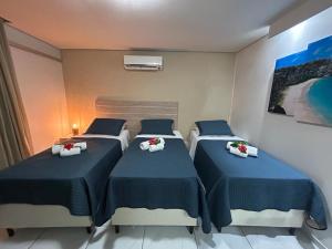 two beds in a hotel room with blue sheets at Marina Noronha Pousada in Fernando de Noronha