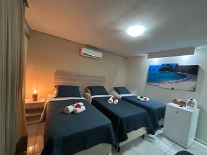 a room with three beds with stuffed animals on them at Marina Noronha Pousada in Fernando de Noronha