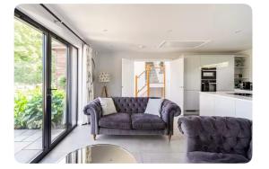 a living room with a purple couch and a kitchen at Modern 2 bed home in idyllic location sleeps 6 Superfast WiFi with onsite Gym in Stagsden
