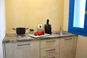 una encimera de cocina con fregadero y algunos tomates en un plato en Terrazze di Bue Marino, en Pantelleria