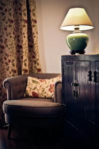 a lamp sitting on top of a cabinet next to a chair at Quinta Verde Sintra - Casa de Campo in Sintra