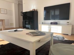 a living room with a white table and a tv at Cozy Corner Treviso Station #4 in Treviso +16 photos