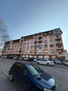 a blue car parked in front of a large building at Gradina Stan na Dan in Doboj
