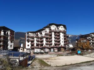 a large apartment building in front of some mountains at Appartement Centre Skis aux Pieds, Parking & Animaux Acceptés - FR-1-513-77 in La Tania