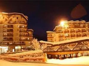 a building with snow on it next to a building at Appartement Centre Skis aux Pieds, Parking & Animaux Acceptés - FR-1-513-77 in La Tania +2 photos