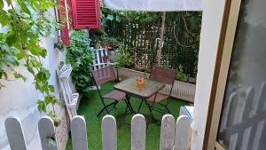 a table and chairs in a backyard with a fence at A casa di Pino in Alghero +8 photos