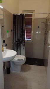 a bathroom with a toilet and a sink and a shower at A casa di Pino in Alghero
