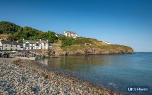 a group of houses on a hill next to the water at 19 St Brides Bay in Haverfordwest