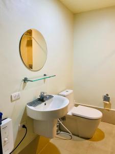 a bathroom with a sink and a toilet and a mirror at Tagaytay Staycation - Kasa Luntian in Tagaytay