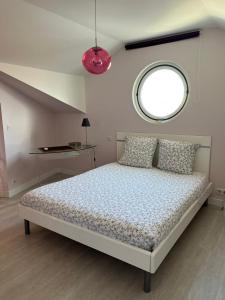 una camera con un letto e una finestra rotonda di Résidence la Rhune a Saint-Jean-de-Luz