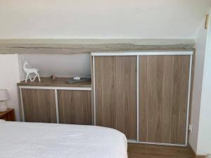 a bedroom with a bed and a wooden cabinet at Le duplex in Compiègne +2 photos