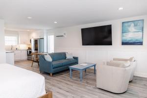 a room with a bed and a couch and a tv at 1001 King ADA Suite, 1st Floor Serenity in Surf City +21 photos