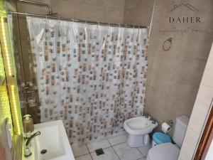 a bathroom with a shower curtain and a toilet at Daher Apartment Homes in La Consulta