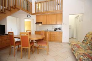 una cucina e una sala da pranzo con tavolo e sedie di Apartments Mikulan Beach a Baška