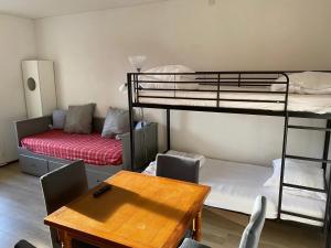 ein Wohnzimmer mit 2 Etagenbetten und einem Tisch in der Unterkunft Charmant studio à Laguiole avec vue montagne 27 m² in Laguiole