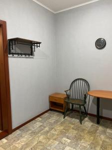 a room with a chair and a table and a clock at Момент in Yuzhnoukrainsk 