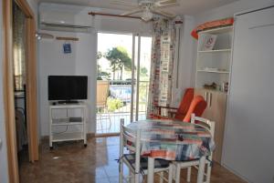 a living room with a table and a television at Oasis Playa de Gandía in Gandía