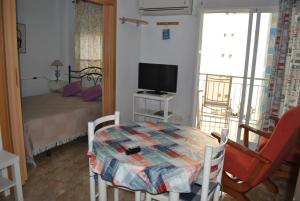 a small living room with a table and a television at Oasis Playa de Gandía in Gandía
