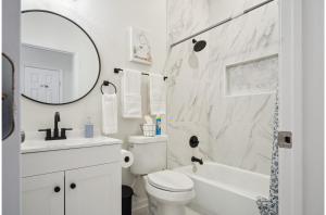 Un baño blanco con inodoro y lavabo. en Blissful 5BR3BA Haven Near Riverwalk Downtown, en San Antonio 37 fotos más