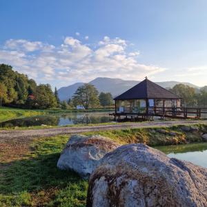 a gazebo next to a lake with some rocks at Fishing and Relax Camp in Bixad