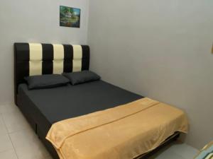 a black and white bed in a room at Teratak HZ Homestay Indera Sempurna Kuantan in Kuantan