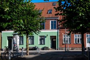 a green building in front of a brick building at Sunway Place in Præstø