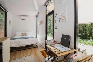 una piccola camera con letto e tavolo di Raspberry Spring Corner by Tiny Away a Clothiers Creek