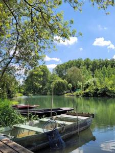a boat sitting on the water next to a dock at ZEcamping 4 étoiles familial avec pataugeoire et jacuzzi in Coulon