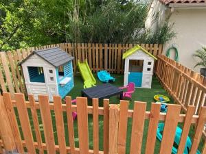 a backyard with childrens play equipment on a fence at ZEcamping 4 étoiles familial avec pataugeoire et jacuzzi in Coulon
