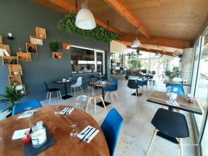 a dining room with a table and blue chairs at ZEcamping 4 étoiles familial avec pataugeoire et jacuzzi in Coulon