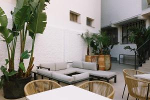 多列毛利诺斯Apartamentos Buendia Suites - Torremolinos Centro的天井配有沙发、椅子和植物