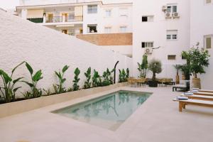 多列毛利诺斯Apartamentos Buendia Suites - Torremolinos Centro的建筑物内设有带游泳池的庭院