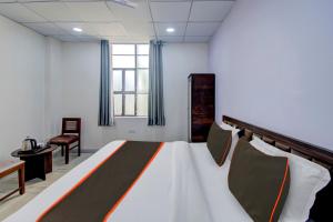 a bedroom with a bed and a desk and a window at Hotel O Connect in Jaipur