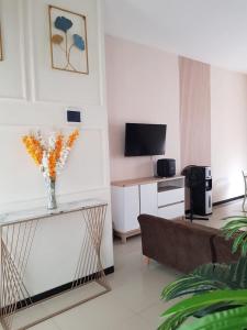 Una sala de estar con un sofá y un televisor. en Villa Neona Nora, en Tlekung